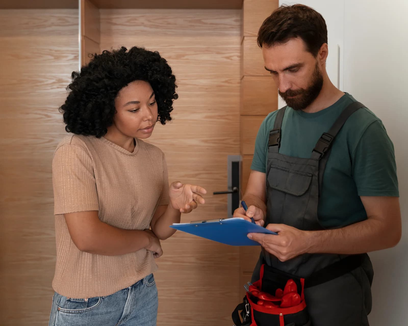 Ein Sanitärhandwerker bespricht die anstehenden Arbeiten mit einer Kundin